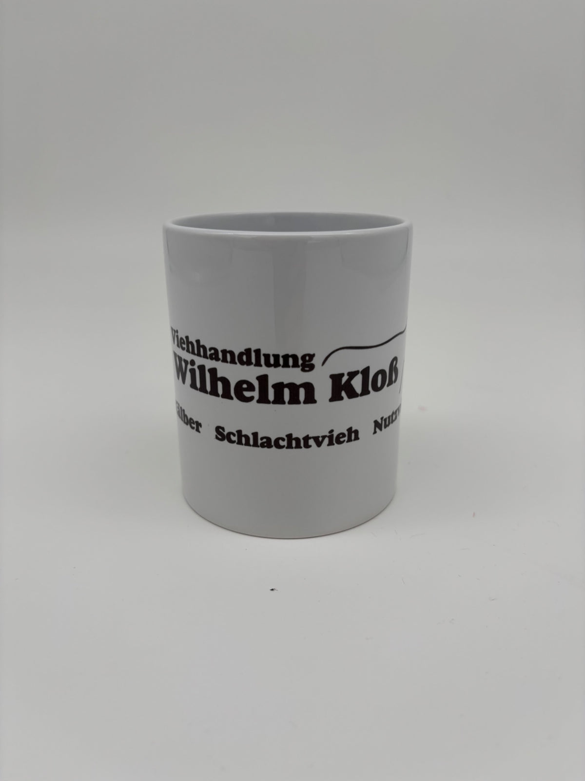 Weiße Kaffeetasse mit individuell gedrucktem schwarzen Logo der Viehhandlung Wilhelm Kloß